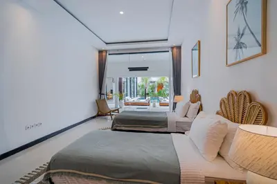 a bedroom with two beds and a living room at Villa Orchid Heaven by Bali Villa Solutions in Seminyak