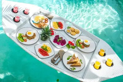 a table with plates of food next to a pool at Villa Orchid Heaven by Bali Villa Solutions in Seminyak