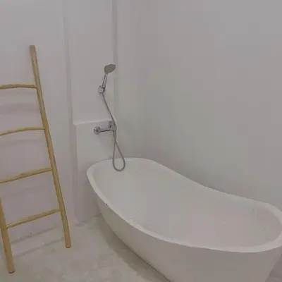 a white bath tub in a room with a ladder at Dakings Greece House in Legian