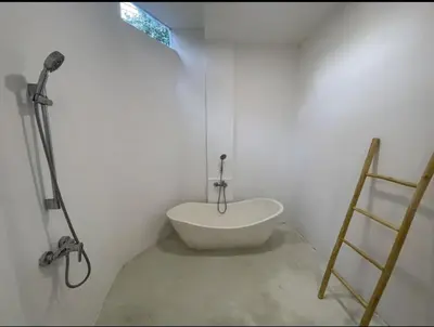 a bathroom with a white tub in a room at Dakings Greece House in Legian