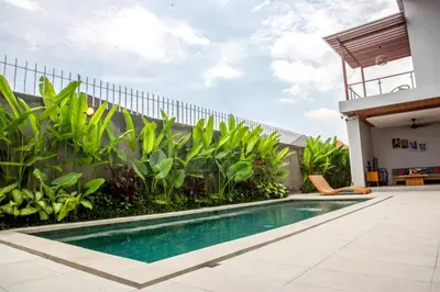 a swimming pool in front of a house at Rumah Melissa - Modern Boho 3BR Brand New Villa in Sanur in Sanur