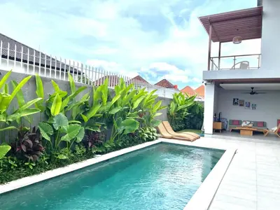 a swimming pool in front of a house with plants at Rumah Melissa - Modern Boho 3BR Brand New Villa in Sanur in Sanur