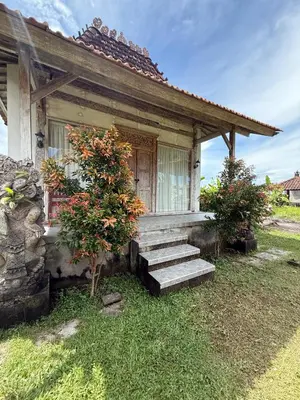 a small house with stairs leading to a door at Balian Retreat Centre Homestay in Sanur