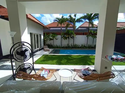 a patio with chairs and a swimming pool at Villa Bu H in Kerobokan
