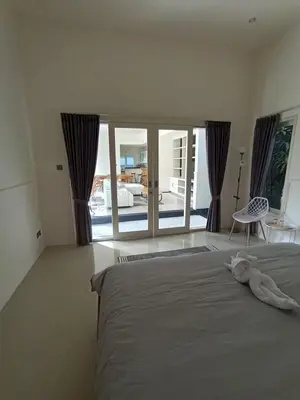 a bedroom with a bed with a stuffed animal on it at Villa Bu H in Kerobokan