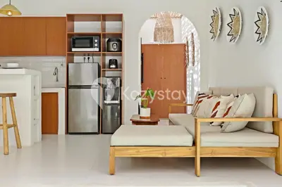 a living room with a couch and a kitchen at Kirelo Villa by Kozystay - Sanur in Sanur