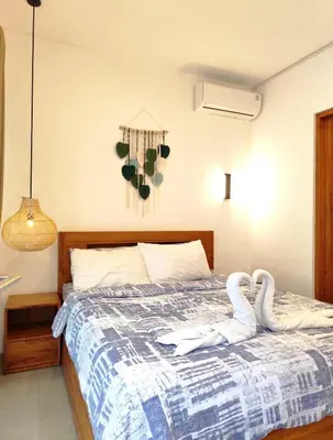 two swans sitting on a bed in a bedroom at Coconut Villa in Kerobokan