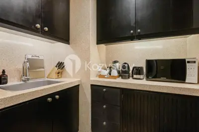 a kitchen with a sink and a microwave at The Koral by Kozystay - Seminyak in Kuta