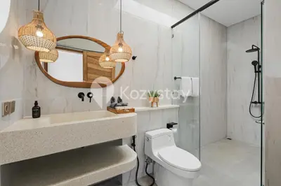 a bathroom with a toilet and a sink and a mirror at Salila Villa by Kozystay - Umalas in Kerobokan