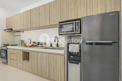 a kitchen with a stainless steel refrigerator and a microwave at Salila Villa by Kozystay - Umalas in Kerobokan