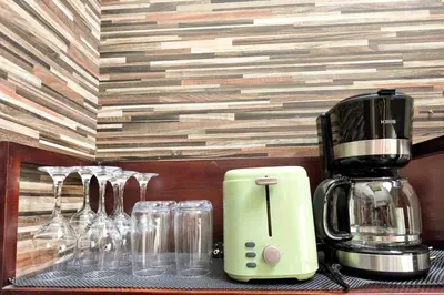 a coffee maker sitting on a counter with wine glasses at Domaxo Villa in Seminyak