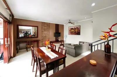 a living room with a dining table and a couch at Domaxo Villa in Seminyak