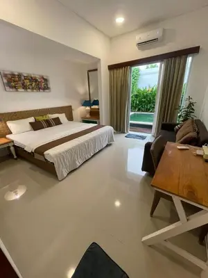 a bedroom with a bed and a living room at Ariani Villa in Jimbaran