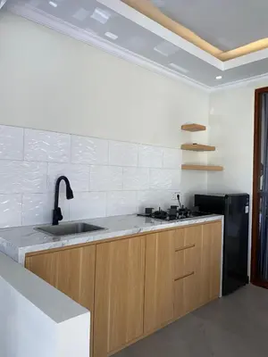 a kitchen with a sink and a black refrigerator at Villa Damai in Sanur