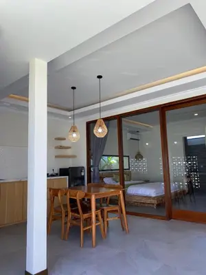 a dining room with a table and chairs and a bedroom at Villa Damai in Sanur