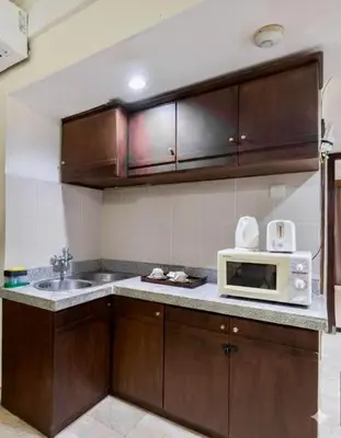 a kitchen with a sink and a microwave at Jayakarta Service Apartments in Seminyak