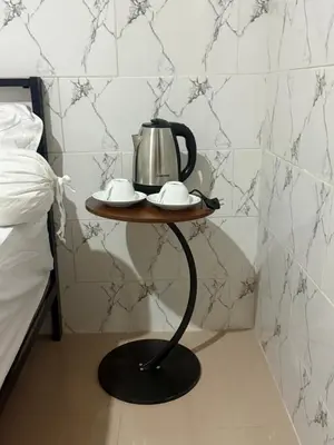 a tea kettle on a table next to a bed at Private Room In Bali 10Mints To Sanur Beach in Sanur
