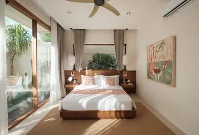 a bedroom with a bed and a ceiling fan at Manu Villas in Sanur