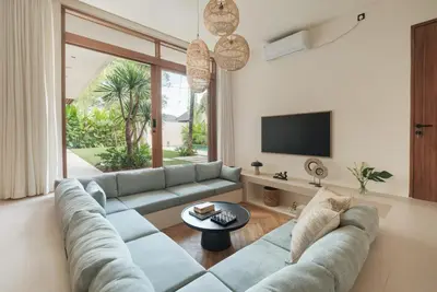 a living room with a couch and a tv at Manu Villas in Sanur