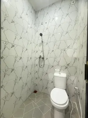 a bathroom with a toilet and a phone on the wall at Private Room Near Sanur Beach Bali in Sanur