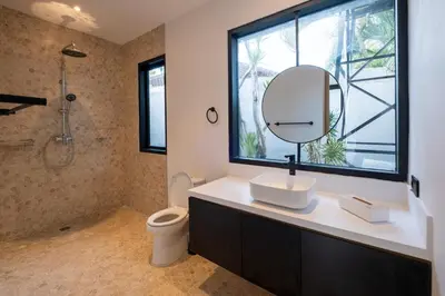 a bathroom with a toilet and a sink and a mirror at Villa Seminyak Beachside Luxury in Seminyak
