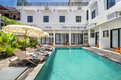 an image of a swimming pool with chairs and a building at Uma Katani in Jimbaran