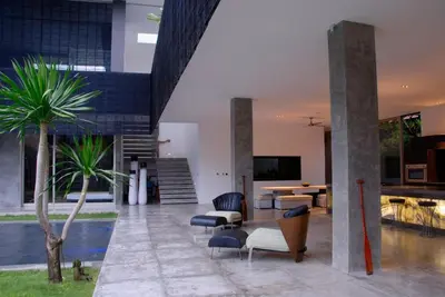 a living room with couches and chairs and a pool at Modern 4BD Villa with Pool in Seminyak
