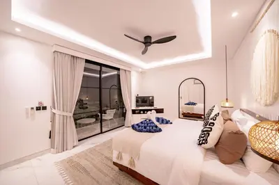 a bedroom with a bed and a ceiling fan at Villa Samyati Kerobokan in Seminyak
