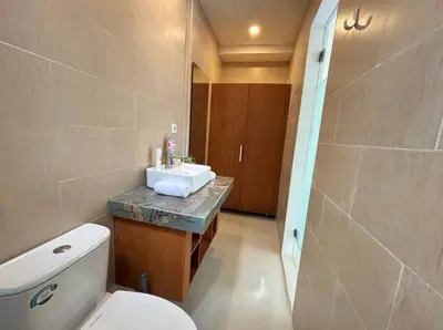 a bathroom with a white toilet and a sink at FrangipaniVilla in Seminyak