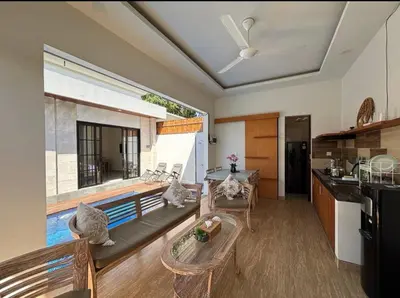 a living room with a couch and a large window at FrangipaniVilla in Seminyak