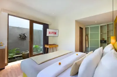 a bedroom with a large white bed and a window at Teagan Pretty 1 BR Royal Private Pool Villa With Waterslide in Kerobokan