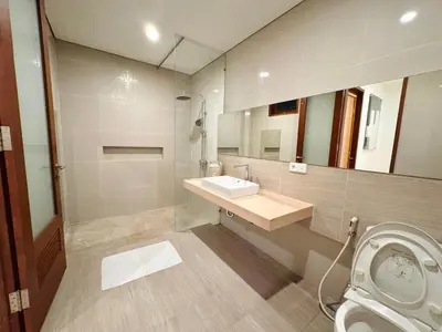 a bathroom with a sink and a mirror and a toilet at Casa Da Luca Beachside Sanur in Sanur