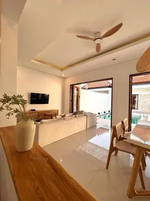 a living room with a couch and a ceiling fan at Casa Da Luca Beachside Sanur in Sanur