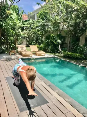 a young child is diving into a swimming pool at The Secreet Garden Hotel in Denpasar