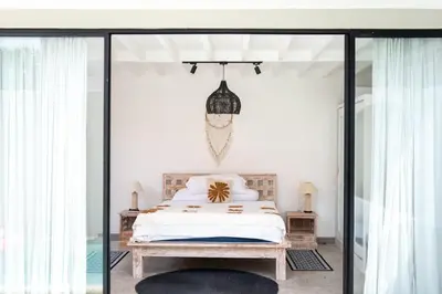 a bedroom with a bed and sliding glass doors at Charming 3 BR villa in the heart of Umalas in Canggu