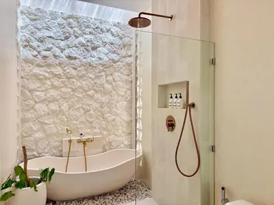 a bathroom with a bath tub and a shower at House of Rakiki Legian - 2BR Private Pool Villa in Central Legian close to Beach in Legian