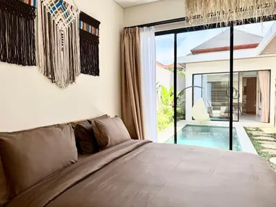 a bedroom with a bed and a view of a pool at House of Rakiki Legian - 2BR Private Pool Villa in Central Legian close to Beach in Legian