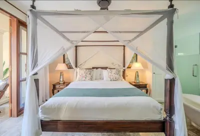 a bedroom with a canopy bed and a tub at Seminyak Pool Villa in Seminyak