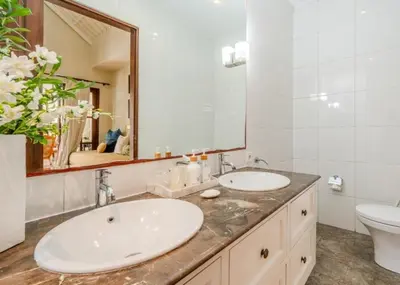 a bathroom with two sinks and a toilet and a mirror at Seminyak Pool Villa in Seminyak