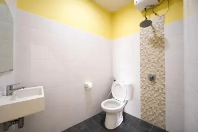 a bathroom with a toilet and a sink at Palm 57 Guest House Legian in Legian