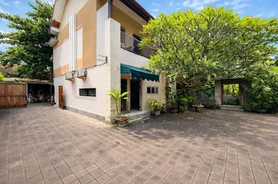 a building with a courtyard in front of it at Palm 57 Guest House Legian in Legian