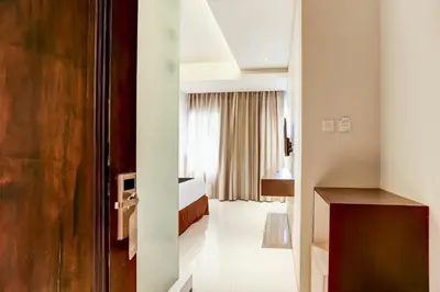 a hotel room with a bedroom and a bed at Collection O Legian Near Pantai Kuta Formerly Premium Legian in Legian