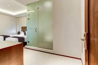 a room with two beds and a glass door at Collection O Legian Near Pantai Kuta Formerly Premium Legian in Legian