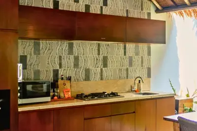a kitchen with a stove and a microwave at Malaya Stunning 1 BR Private Pool Villa With Bathtub in Seminyak