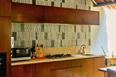 a kitchen with a stove and a microwave at Malayna Comfortable 2 BR Royal Private Pool Villa in Seminyak