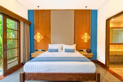 a bedroom with a large bed with blue walls at Malayna Comfortable 2 BR Royal Private Pool Villa in Seminyak
