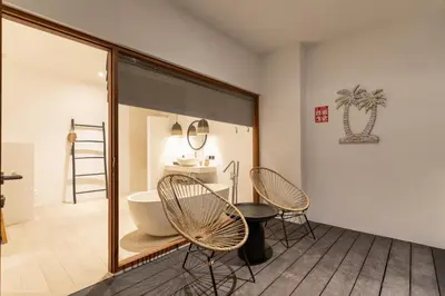 a bathroom with two chairs and a tub and a sink at Villa Sora by Alfred in Bali in Seminyak