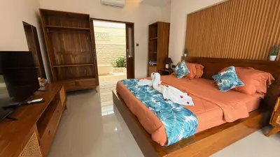 two children are laying on a bed in a bedroom at Emstaliese & Palmarosa Villas Seminyak in Legian