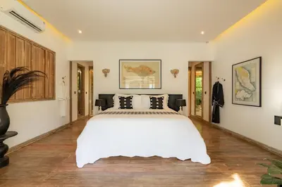 a bedroom with a large white bed and wooden floors at Luxe Bali Seminyak Villa by Betterplace in Seminyak