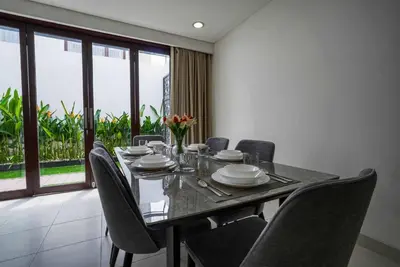 a dining room with a table and chairs at Norm Villa Kuta in Kuta